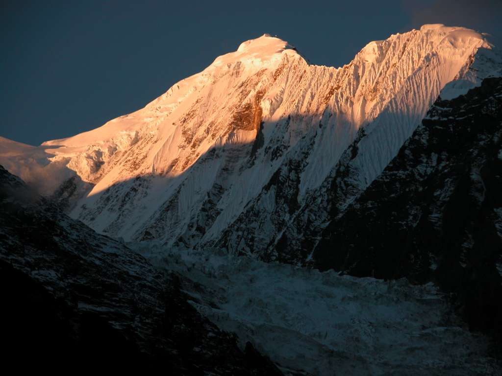 Annapurna 13 04 Gangapurna Sunrise From Manang Gangapurna (7455m) shone in the morning sun from Manang. Gangapurna was first climbed on May 6, 1965 via the East Ridge by a Gunter Hauser, Ludwig Greissl, Hermann Kollensperger, Erich Reismueller, Ang Temba Sherpa, and Phu Dorje Sherpa.